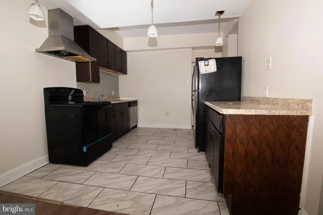 a kitchen with stainless steel appliances granite countertop a refrigerator and a stove