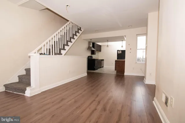 a view of a hallway with wooden floor and staircase