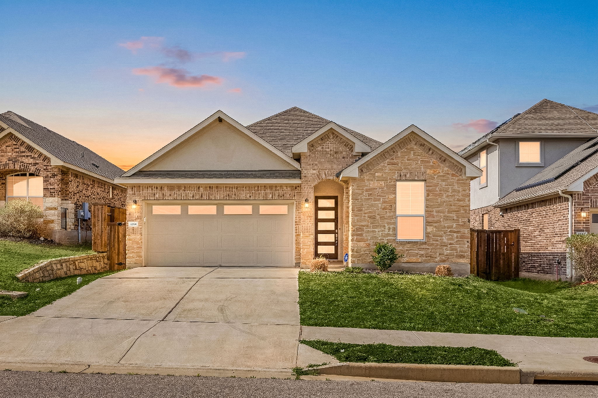 Front of property featuring a lawn, an attached garage, concrete driveway, and a shingled roof
