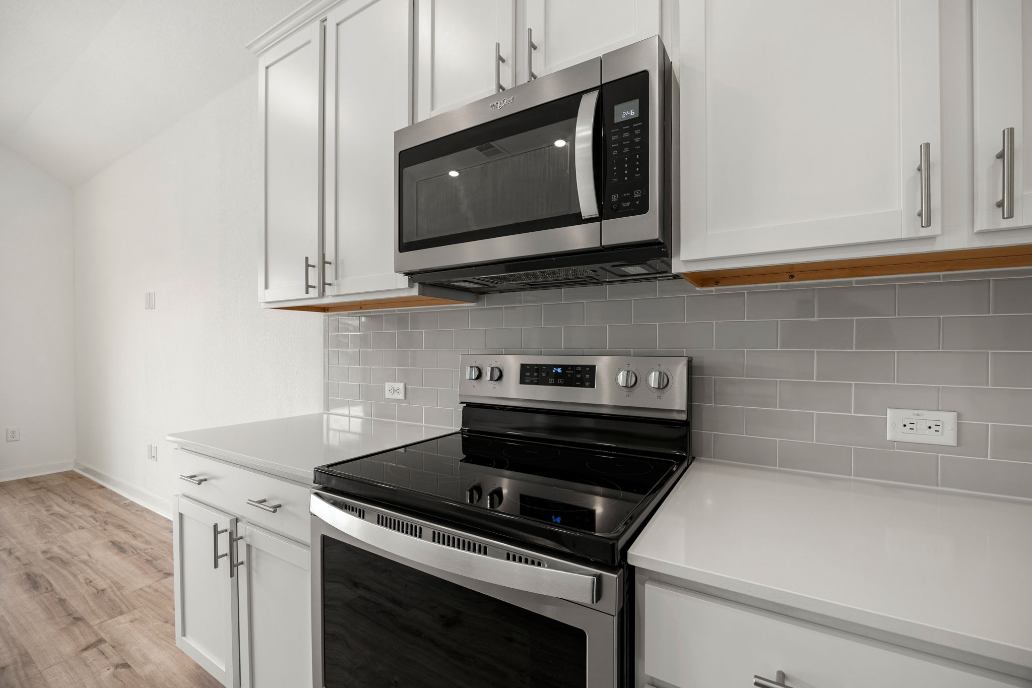 904 Balsora Cove Georgetown, TX 78628 - Photo 12 of 40 Kitchen featuring stainless steel appliances, white cabinets, tasteful backsplash, and vaulted ceiling