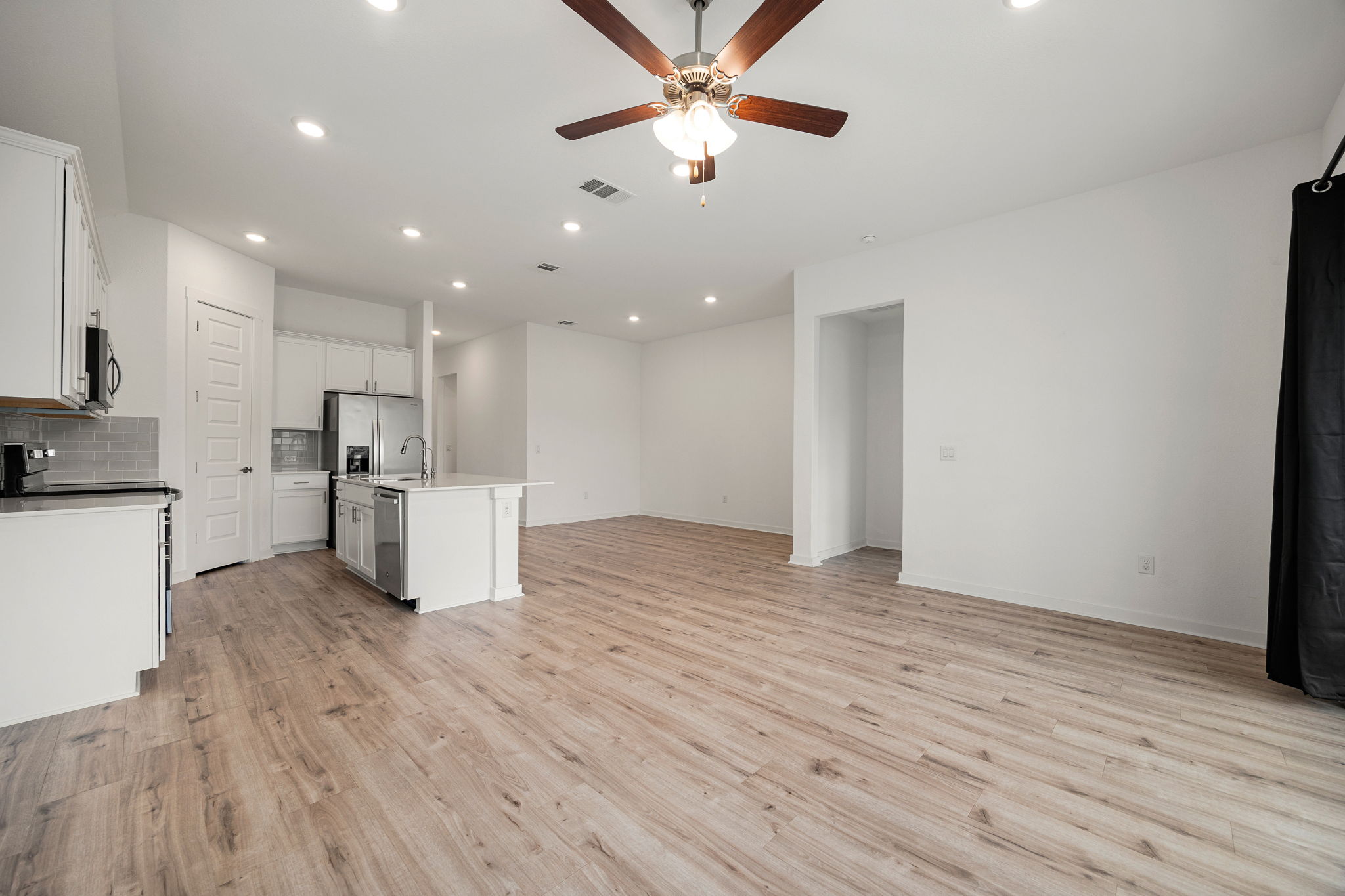 904 Balsora Cove Georgetown, TX 78628 - Photo 17 of 40 Living room with ceiling fan, light wood-like vynil flooring, recessed lighting, and vaulted ceiling