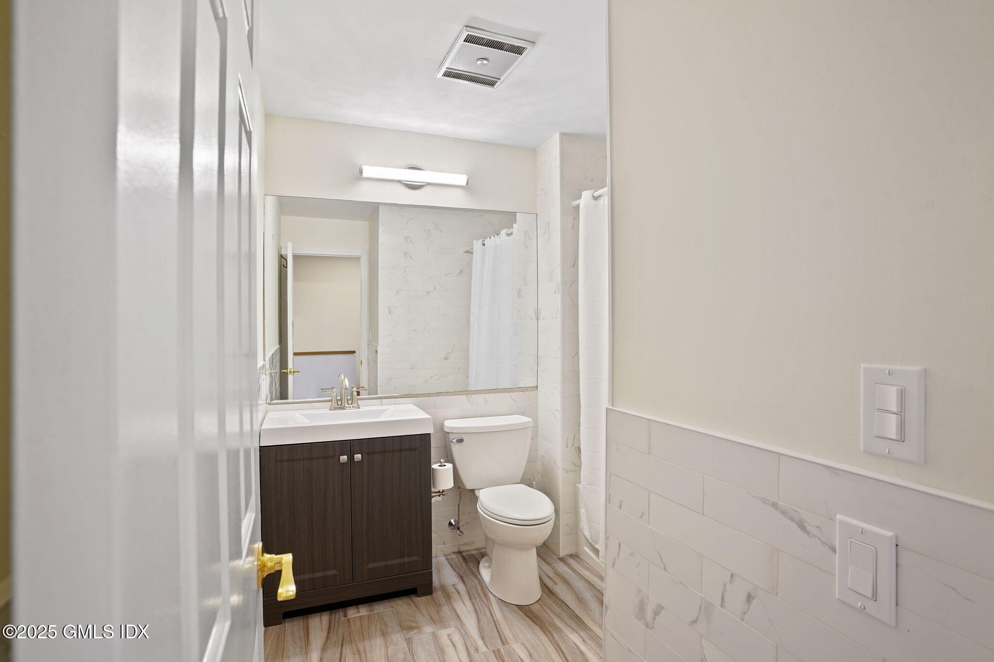 7 River Road, Unit 310 Cos Cob, CT 06807 - Photo 12 of 19 a bathroom with a granite countertop toilet a sink and a mirror