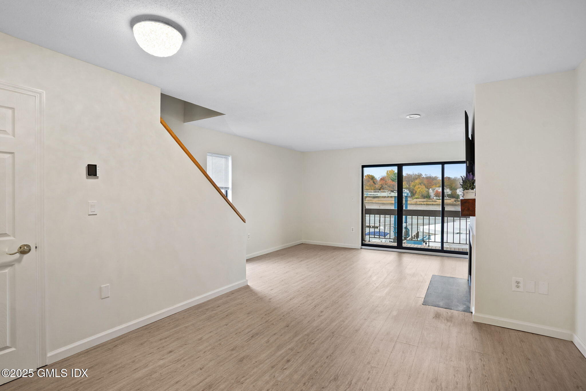 7 River Road, Unit 310 Cos Cob, CT 06807 - Photo 9 of 19 an empty room with wooden floor and windows