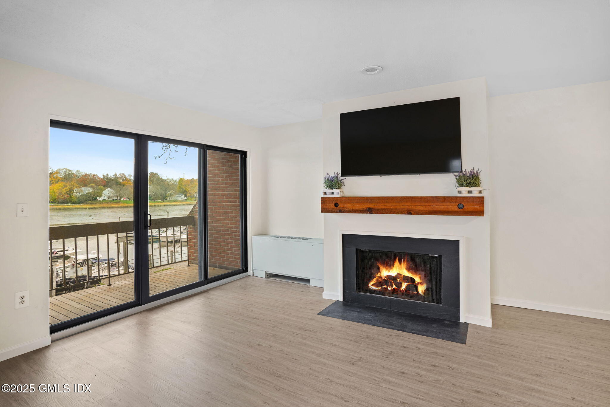 7 River Road, Unit 310 Cos Cob, CT 06807 - Photo 10 of 19 a living room with a fireplace a flat screen tv and a fireplace