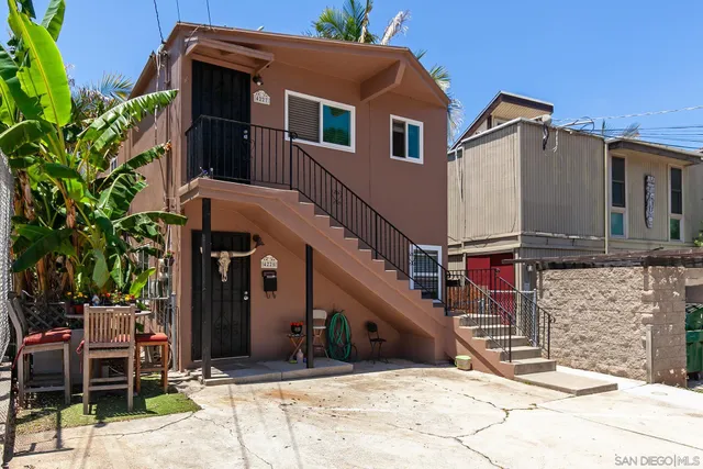 a view of a house with a small yard and potted plants