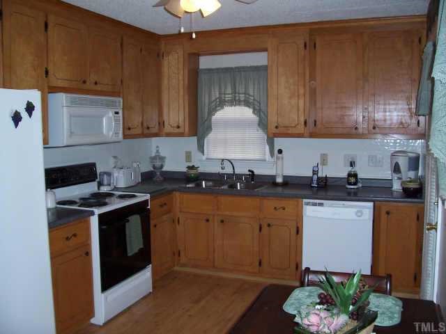 6503 Whitt Road Durham, NC 27712 - Photo 3 of 10 a kitchen with stainless steel appliances granite countertop a stove a sink dishwasher and a refrigerator
