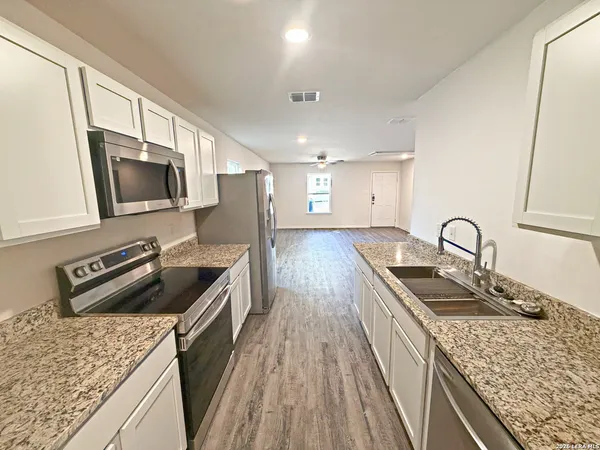 a kitchen with sink stove and refrigerator