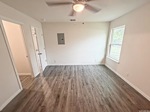 an empty room with wooden floor and windows