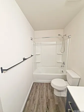 a bathroom with a granite countertop bathtub shower sink vanity and toilet