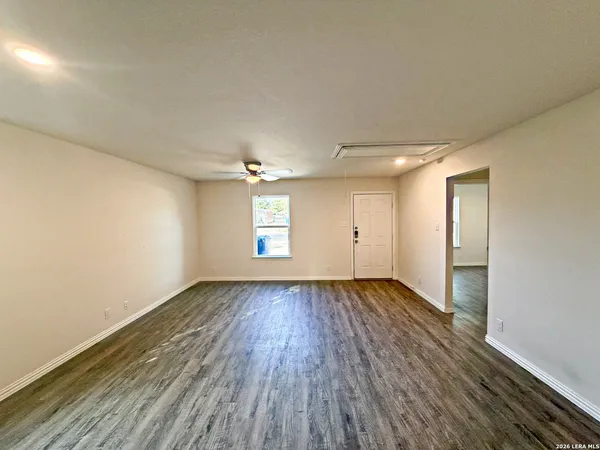 an empty room with wooden floor and windows