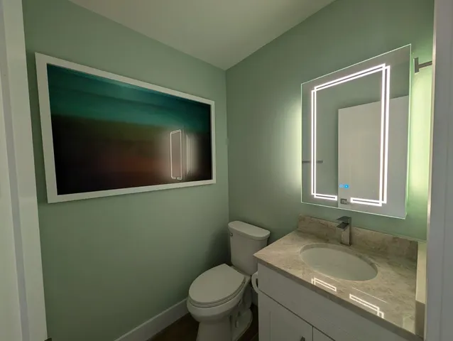 a bathroom with a toilet sink and mirror