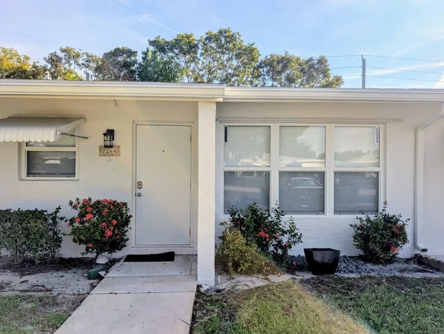 a flower garden is sitting in front of a house