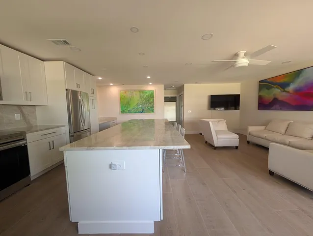 a living room with furniture and a kitchen