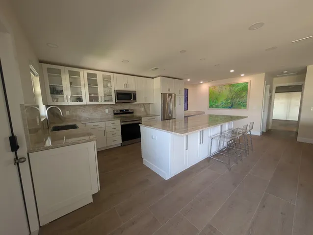 a kitchen with stainless steel appliances granite countertop a refrigerator and a stove top oven