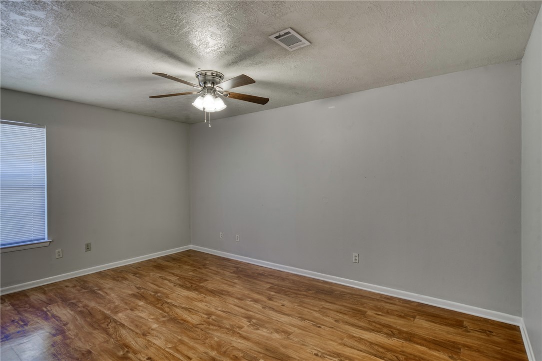 902 Spring Loop, Unit B College Station, TX 77840 - Photo 7 of 10 Spare room featuring light wood-type flooring, a textured ceiling, and a ceiling fan