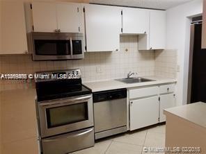 6943 Southwest 40th Street, Unit 11R Miramar, FL 33023 - Photo 3 of 11 a kitchen with stainless steel appliances a stove a microwave and cabinets