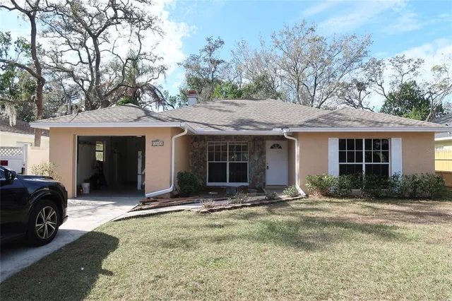 a front view of a house with a garden and trees