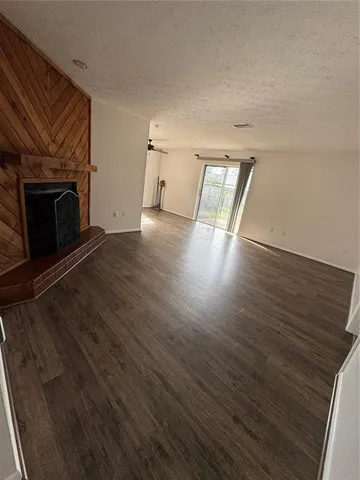 an empty room with wooden floor and a fireplace