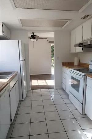 a kitchen with a stove a refrigerator and cabinets