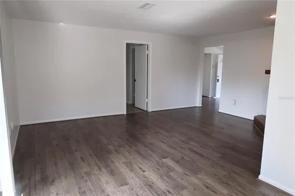 an empty room with wooden floor and closet