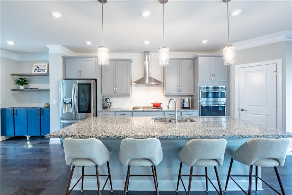 4062 Townsend Lane Atlanta, GA 30346 - Photo 12 of 52 a kitchen with stainless steel appliances granite countertop a kitchen island a stove a sink a dining table and chairs with wooden floor