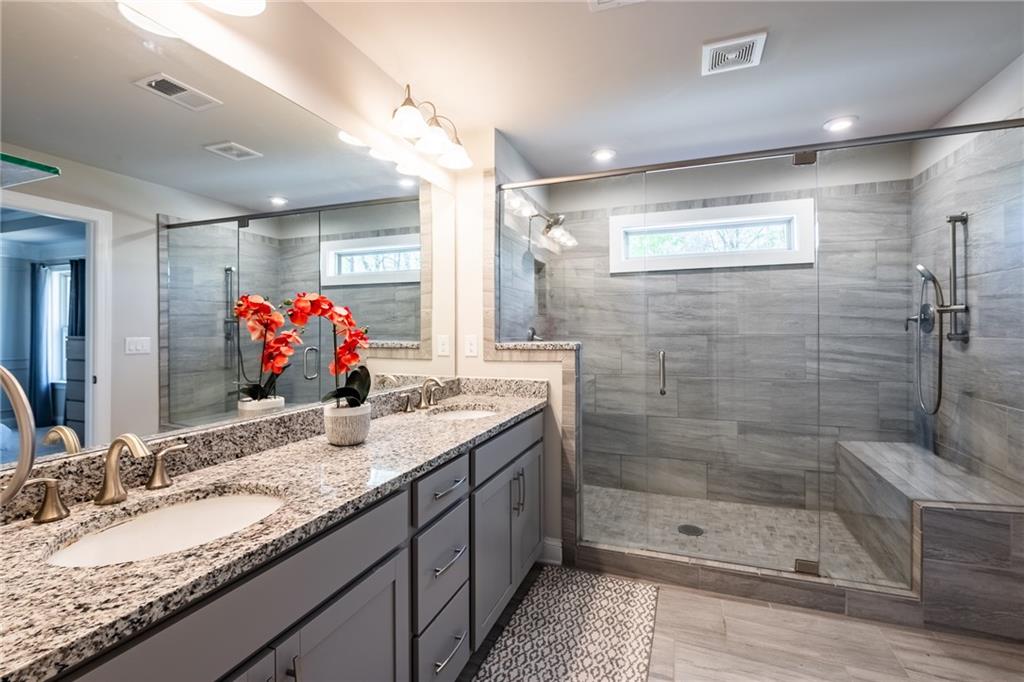 4062 Townsend Lane Atlanta, GA 30346 - Photo 25 of 52 a bathroom with a granite countertop sink a large mirror and shower