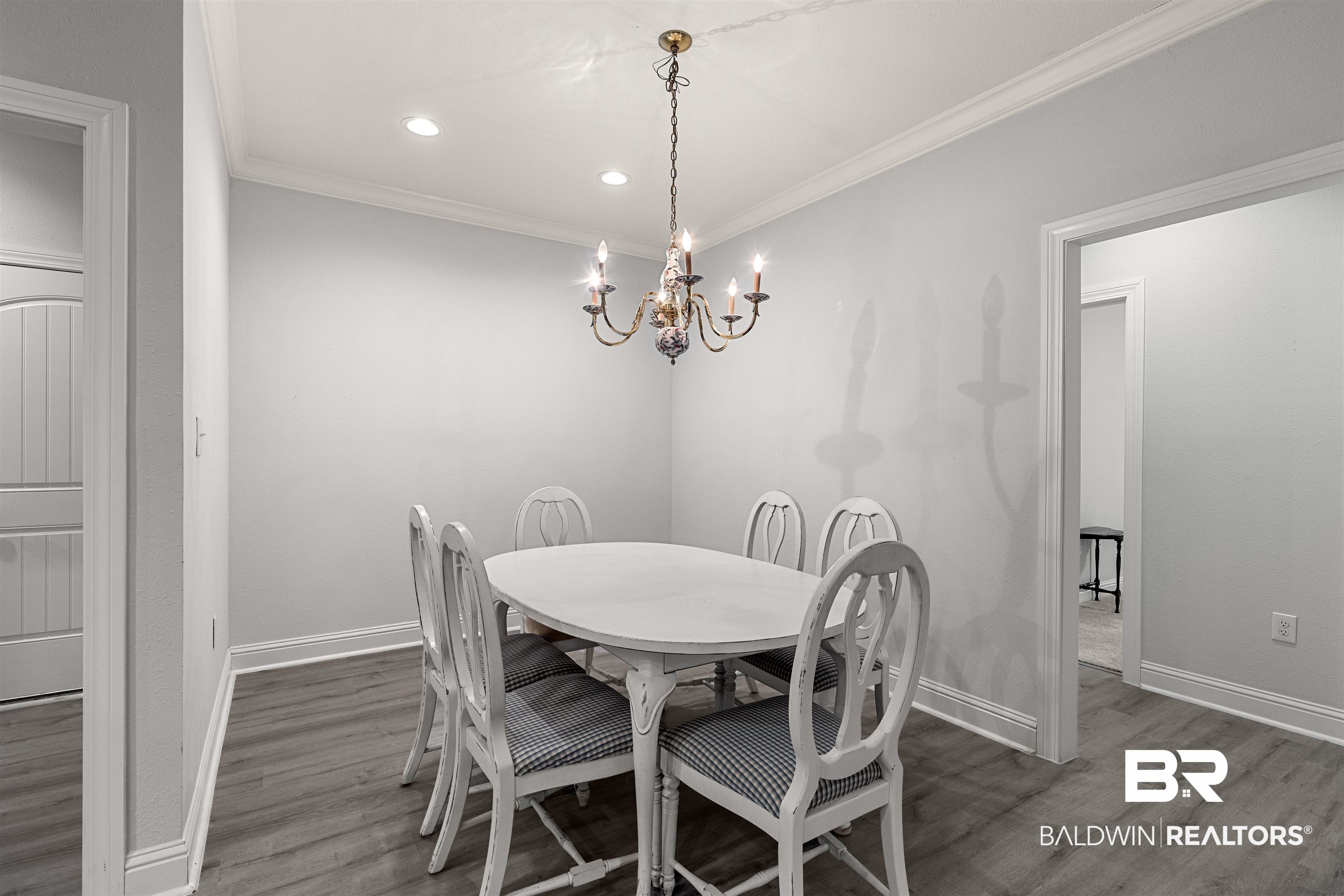 702 Holmes Avenue, Unit 702 Foley, AL 36535 - Photo 11 of 33 Dining space featuring ornamental molding, dark hardwood / wood-style flooring, and an inviting chandelier
