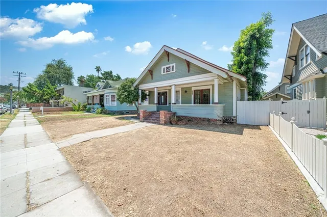 a front view of a house with a yard and potted plants