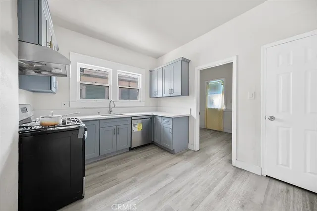 a kitchen with a sink cabinets and wooden floor