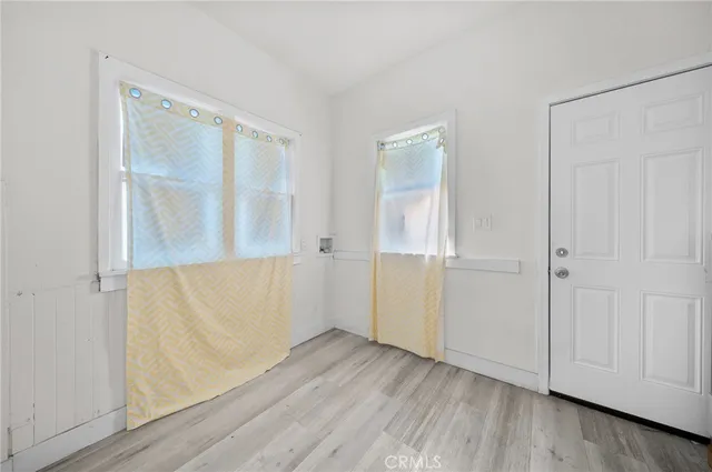 an empty room with wooden floor and cabinet