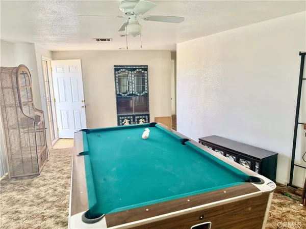 a room with pool table and windows