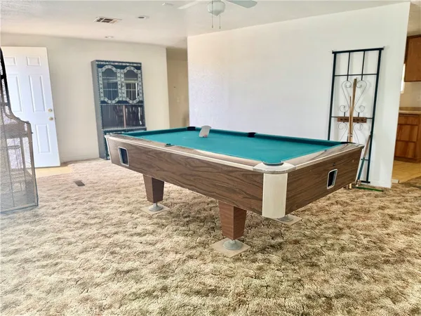 a room with pool table and windows