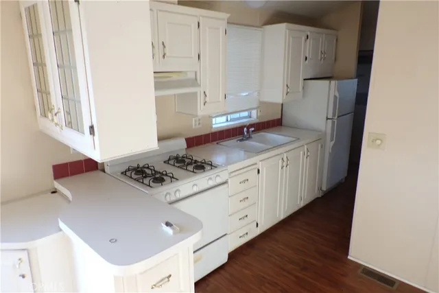 a kitchen with stainless steel appliances granite countertop a stove a refrigerator and a cabinets