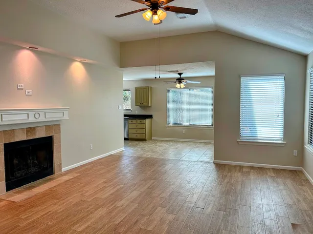 a view of an empty room with a fireplace and a window