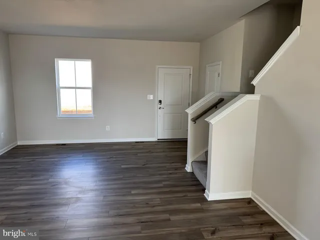 a view of hallway with stairs and wooden floor