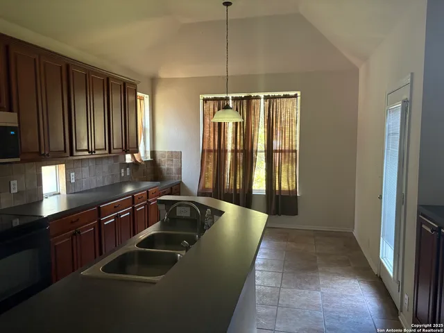 a kitchen with stainless steel appliances granite countertop a sink and a refrigerator