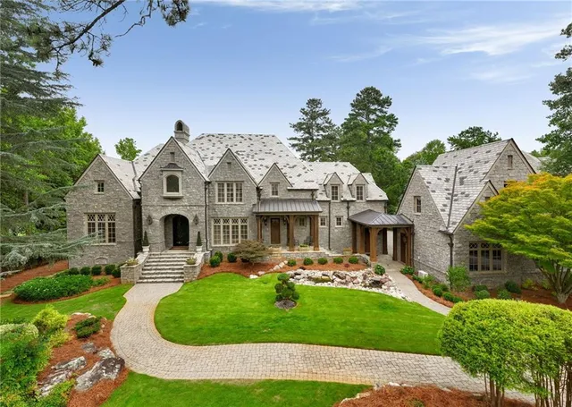 a dining room with couch large windows and a chandelier