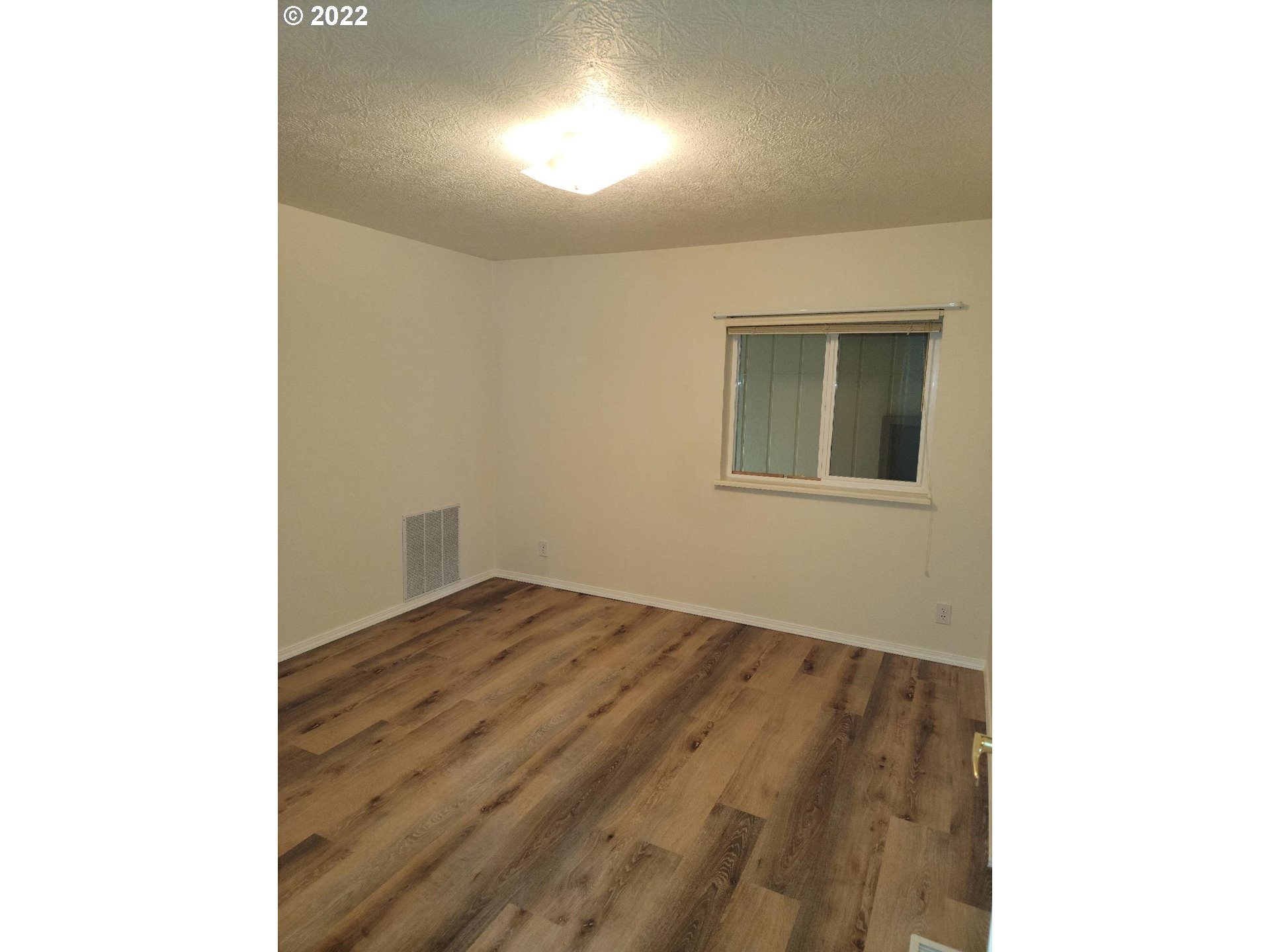 25222 East Welches Road, Unit 8 Welches, OR 97067 - Photo 9 of 31 a view of an empty room with wooden floor and a window