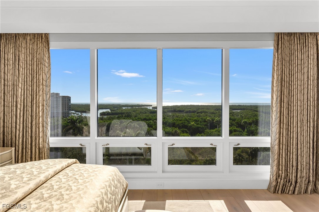 13915 Old Coast Road, Unit 802 Naples, FL 34110 - Photo 16 of 33 a bedroom with a large window and a balcony view