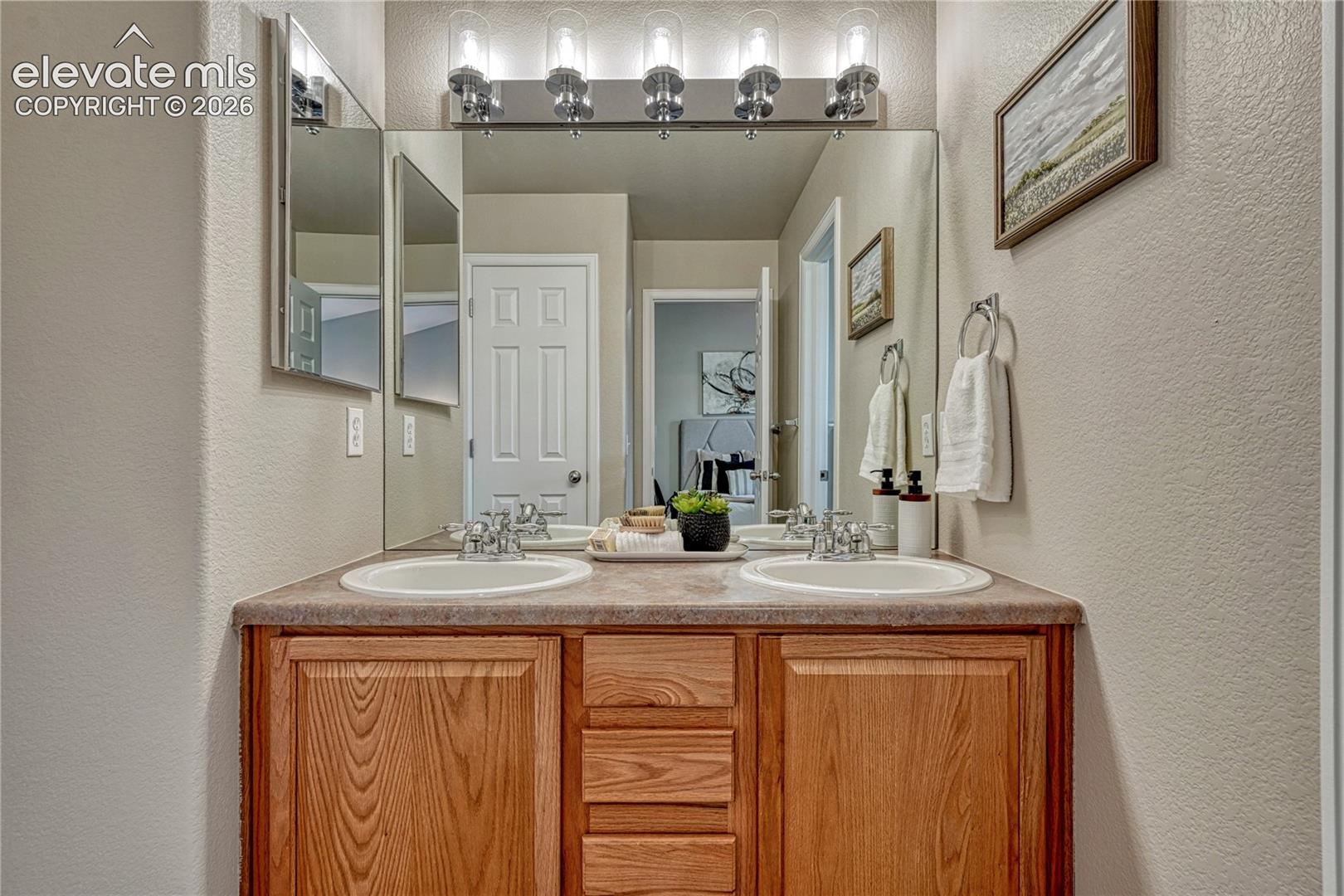 4147 Diamond Ridge View Colorado Springs, CO 80918 - Photo 22 of 42 A generous double-sink vanity and built-in medicine cabinet in the primary bathroom makes busy morning routines comfortable and easy