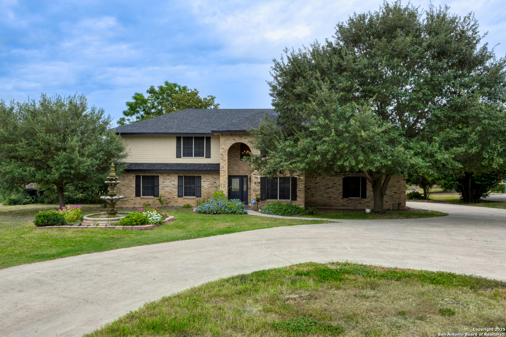 a front view of a house with a yard and trees