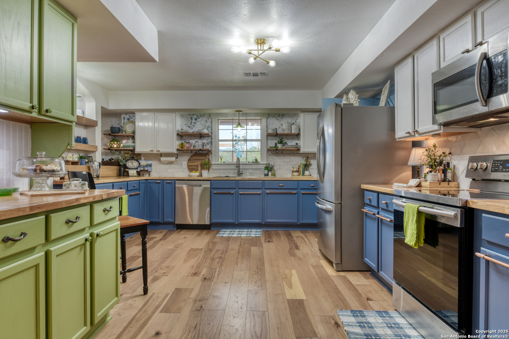 510 Rudeloff Road Seguin, TX 78155 - Photo 16 of 54 a kitchen with stainless steel appliances kitchen island granite countertop wooden floors and sink