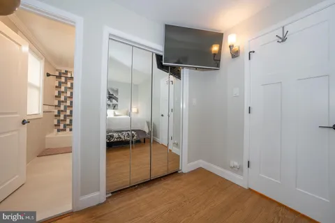 a view of a room with wooden floor cabinet and a bathroom