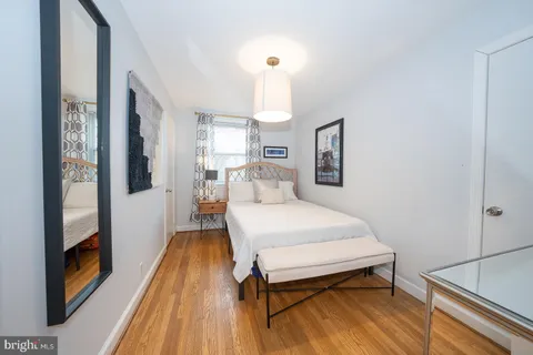 a spacious bedroom with a bed and a dresser