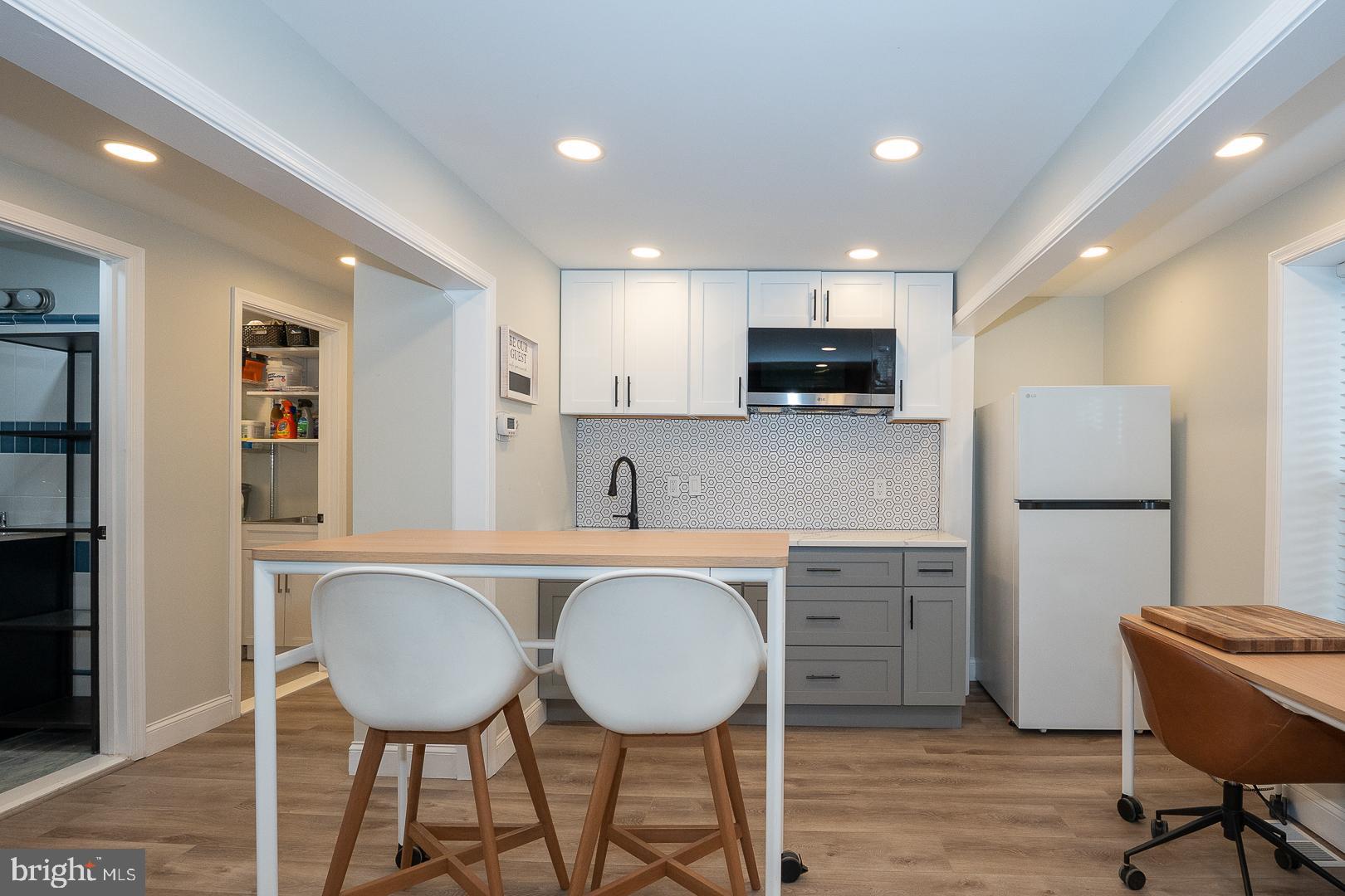 1022 Clover Hill Road Wynnewood, PA 19096 - Photo 23 of 40 a kitchen with stainless steel appliances a refrigerator and a stove top oven with wooden floor