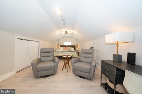 a living room with furniture a flat screen tv and kitchen view