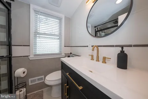 a bathroom with a sink a toilet and a mirror