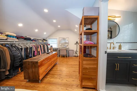 a view of walk in closet with clothes and shoes