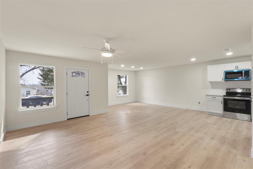 5124 Kilpatrick Avenue Fort Worth, TX 76107 - Photo 4 of 31 an empty room with windows and ceiling fan