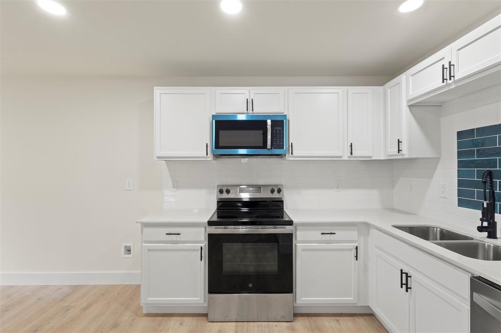 5124 Kilpatrick Avenue Fort Worth, TX 76107 - Photo 10 of 31 a kitchen with white cabinets and black appliances